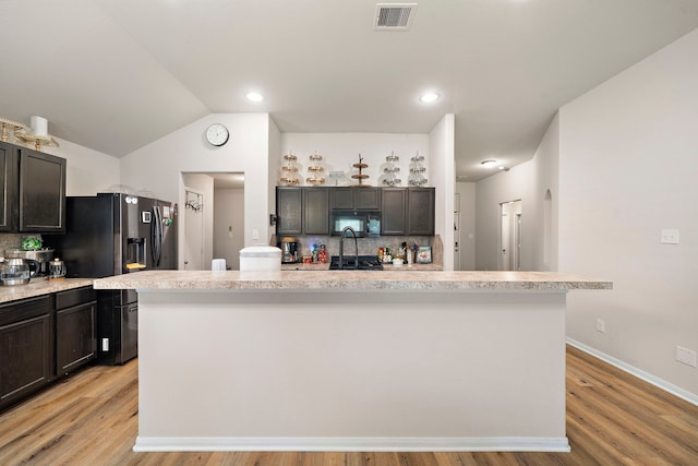11311 Cascading Stream Way, Houston, TX 77044 - kitchen with black microwave, fridge with ice dispenser, light countertops, backsplash, and light wood finished floors