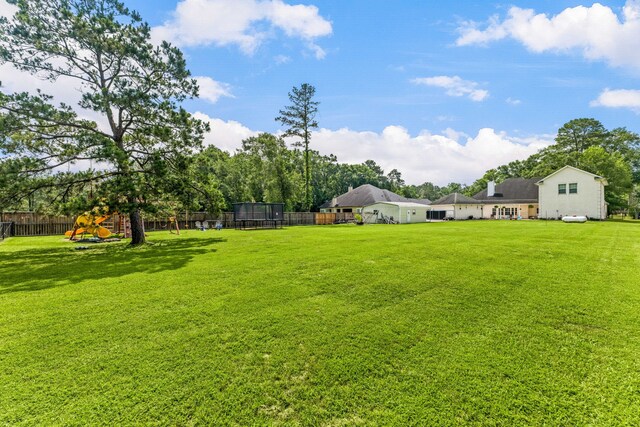 19509 Desna Dr, Porter, TX 77365 - view of yard with a trampoline and a playground