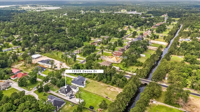 19509 Desna Dr, Porter, TX 77365 - aerial overview of property's location with a heavily wooded area, nearby suburban area, and a large body of water