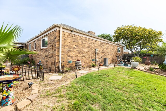 29 Quintana Dr, Galveston, TX 77554 - back of property with a patio, brick siding, and a chimney
