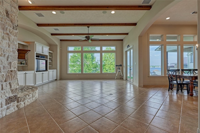 19926 Gemstone Dr, Montgomery, TX 77356 - unfurnished living room with a ceiling fan, baseboards, arched walkways, recessed lighting, and beamed ceiling