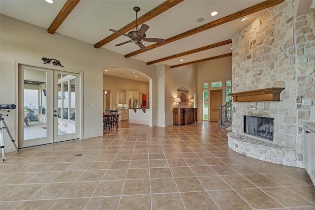 19926 Gemstone Dr, Montgomery, TX 77356 - living room featuring beamed ceiling, a ceiling fan, light tile patterned floors, arched walkways, and french doors