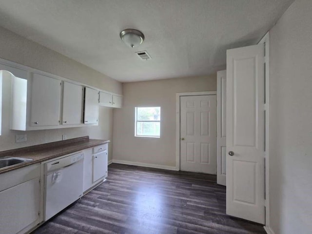 1300 Burbank St, Baytown, TX 77520 - kitchen with white dishwasher, dark wood finished floors, dark countertops, and white cabinets