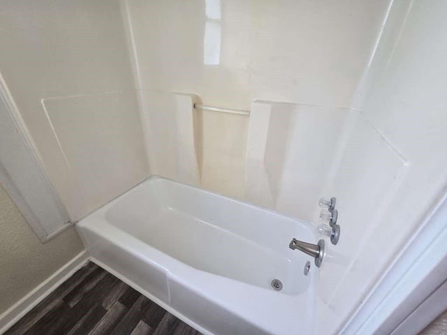1300 Burbank St, Baytown, TX 77520 - full bath featuring wood finished floors, baseboards, and shower / washtub combination