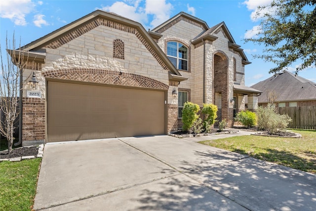 2023 Aspen Point Ln, Richmond, TX 77469 - french country inspired facade featuring stone siding, concrete driveway, a garage, fence, and brick siding