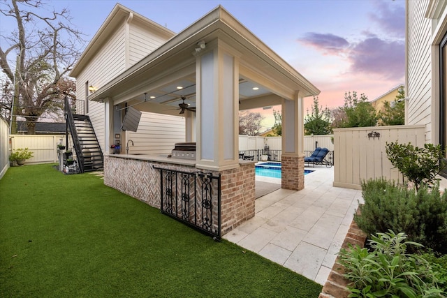 300 E 26th St, Houston, TX 77008 - patio terrace at dusk featuring stairway, exterior kitchen, ceiling fan, and a sink