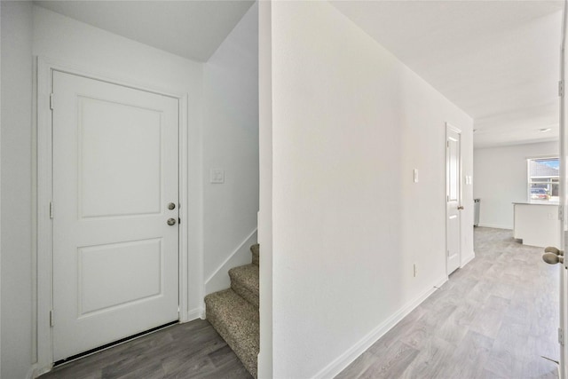 foyer with wood finished floors, stairs, and baseboards
