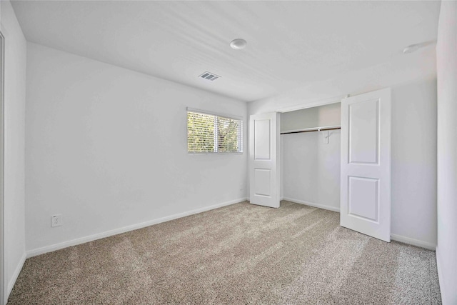 unfurnished bedroom with carpet floors, a closet, and baseboards