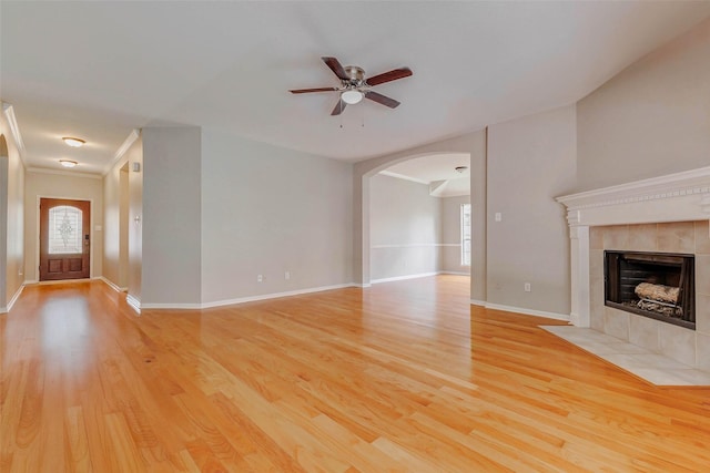 14418 Dunsmore Pl, Cypress, TX 77429 - unfurnished living room with arched walkways, plenty of natural light, a ceiling fan, light wood finished floors, and ornamental molding