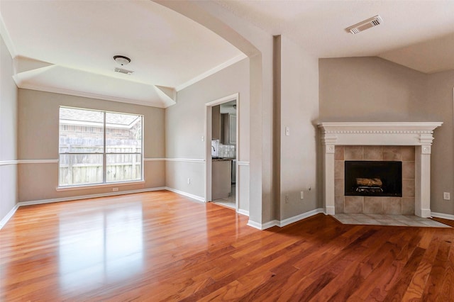 14418 Dunsmore Pl, Cypress, TX 77429 - unfurnished living room with wood finished floors, a fireplace, arched walkways, and crown molding