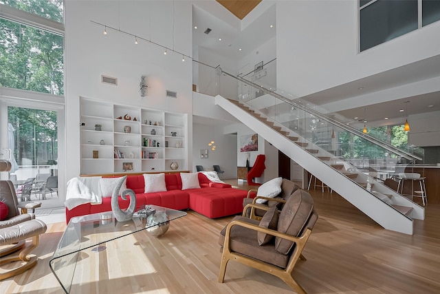 118 Angel Leaf Rd, The Woodlands, TX 77380 - living area featuring a high ceiling, wood finished floors, stairway, and healthy amount of natural light