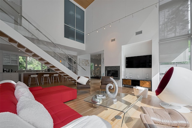118 Angel Leaf Rd, The Woodlands, TX 77380 - living room with stairway, a high ceiling, wood finished floors, and a fireplace