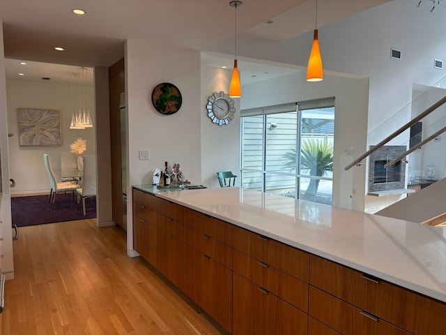 118 Angel Leaf Rd, The Woodlands, TX 77380 - kitchen featuring light wood finished floors, light countertops, modern cabinets, hanging light fixtures, and recessed lighting