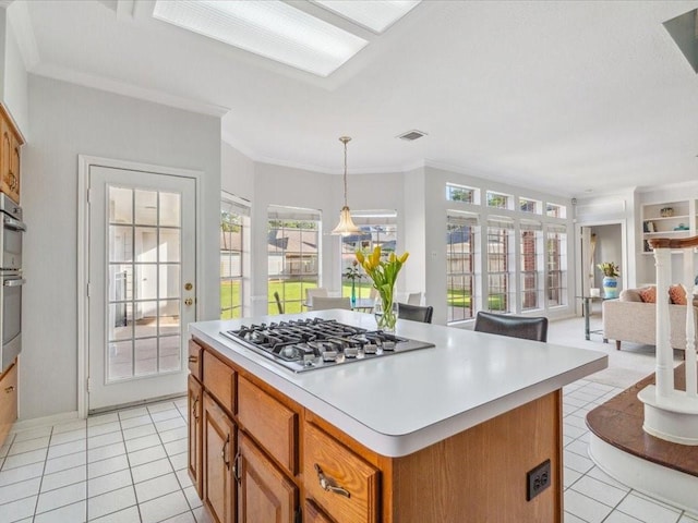 4614 Jamaica Dr, Sugar Land, TX 77479 - kitchen featuring stainless steel gas stovetop, light countertops, light tile patterned floors, open floor plan, and ornamental molding