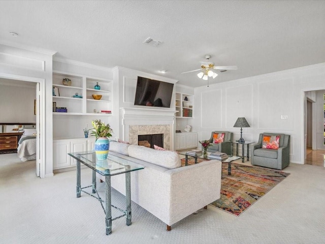4614 Jamaica Dr, Sugar Land, TX 77479 - living room featuring light carpet, a ceiling fan, ornamental molding, a fireplace, and built in shelves