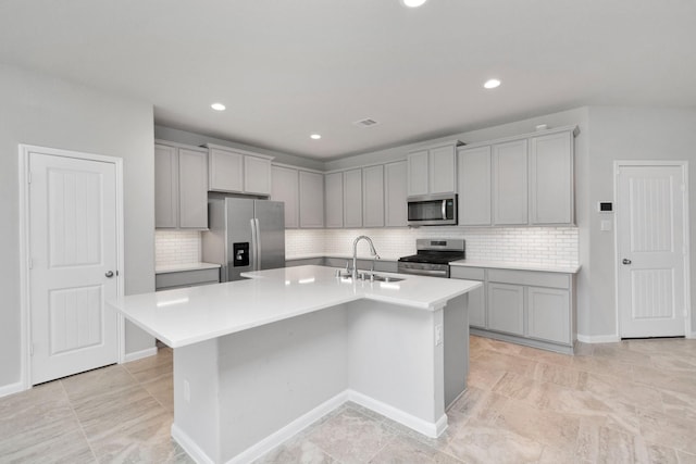 3804 Lancer Cir, Pearland, TX 77581 - kitchen with appliances with stainless steel finishes, a sink, light countertops, an island with sink, and decorative backsplash
