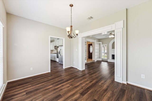 10906 Harvest Sun Dr, Houston, TX 77064 - unfurnished dining area featuring a ceiling fan, a chandelier, dark wood-type flooring, and baseboards