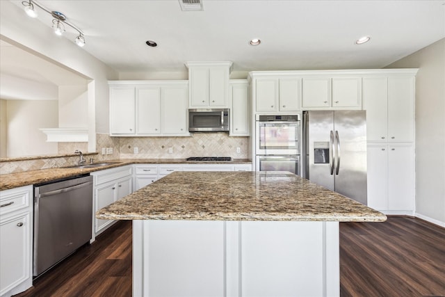 10906 Harvest Sun Dr, Houston, TX 77064 - kitchen featuring appliances with stainless steel finishes, a sink, dark wood-type flooring, white cabinets, and light stone counters