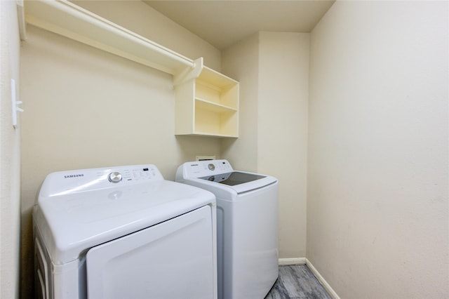 washroom with independent washer and dryer, wood finished floors, and baseboards