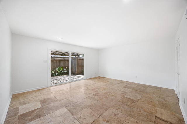 empty room featuring stone finish flooring and baseboards