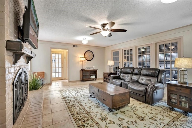 18435 Point Lookout Dr, Houston, TX 77058 - living area featuring ceiling fan, a textured ceiling, light tile patterned floors, and a fireplace