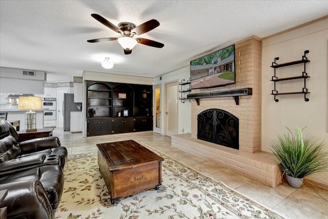 18435 Point Lookout Dr, Houston, TX 77058 - living area featuring a ceiling fan, a textured ceiling, tile patterned floors, and a fireplace