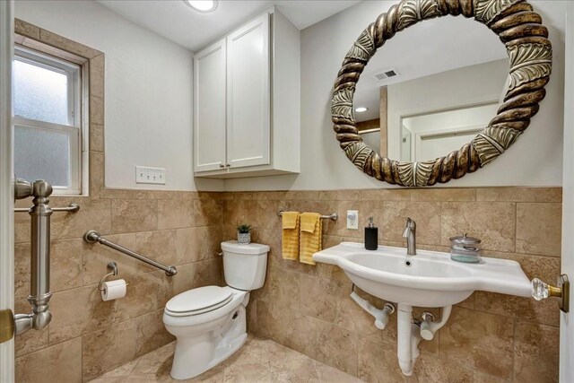 18435 Point Lookout Dr, Houston, TX 77058 - bathroom with toilet, tile walls, and a wainscoted wall