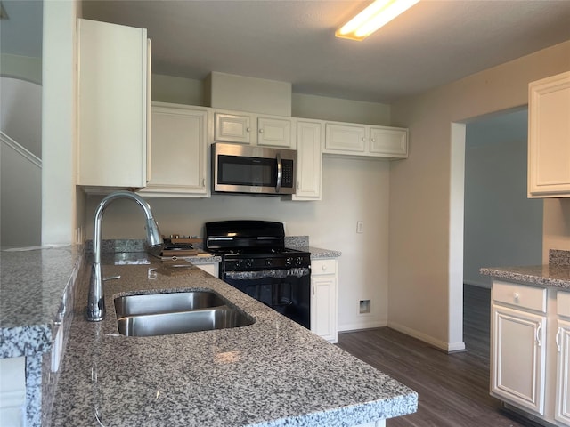 5918 Fergis Dr, Katy, TX 77449 - kitchen with stainless steel microwave, gas stove, a sink, stone countertops, and dark wood-style floors