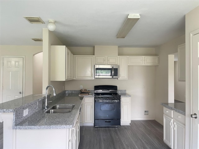 5918 Fergis Dr, Katy, TX 77449 - kitchen featuring stainless steel microwave, black gas range oven, a sink, light stone counters, and dark wood finished floors