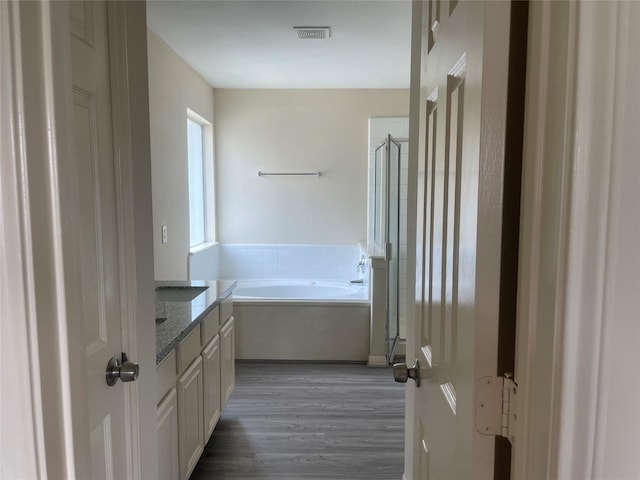 5918 Fergis Dr, Katy, TX 77449 - bathroom featuring wood finished floors, a shower stall, a garden tub, and vanity
