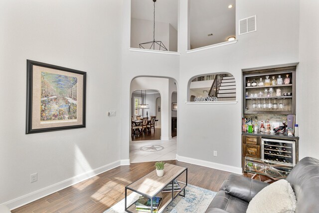 6203 Aspen Pass Dr, Kingwood, TX 77345 - living area with arched walkways, beverage cooler, a dry bar, wood finished floors, and baseboards