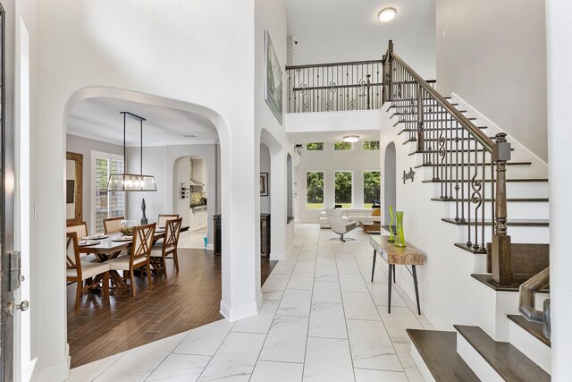 6203 Aspen Pass Dr, Kingwood, TX 77345 - entrance foyer featuring stairs, baseboards, marble look tile flooring, and a towering ceiling