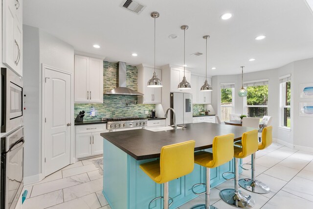 6203 Aspen Pass Dr, Kingwood, TX 77345 - kitchen with wall chimney range hood, dark countertops, appliances with stainless steel finishes, backsplash, and baseboards