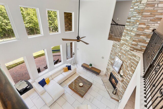6203 Aspen Pass Dr, Kingwood, TX 77345 - living area featuring a high ceiling, plenty of natural light, a stone fireplace, ceiling fan, and stairs