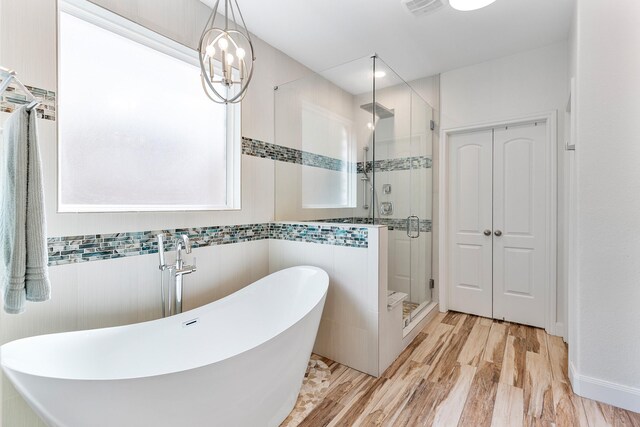 6203 Aspen Pass Dr, Kingwood, TX 77345 - bathroom with a freestanding bath, a stall shower, wood finished floors, and tile walls