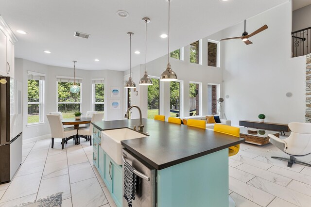 6203 Aspen Pass Dr, Kingwood, TX 77345 - kitchen with dark countertops, a sink, freestanding refrigerator, ceiling fan, and light marble finish floors