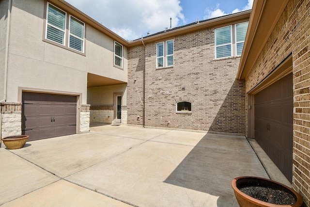 28011 Burnett Hills Ln, Fulshear, TX 77441 - view of side of property featuring a garage, stucco siding, brick siding, and concrete driveway
