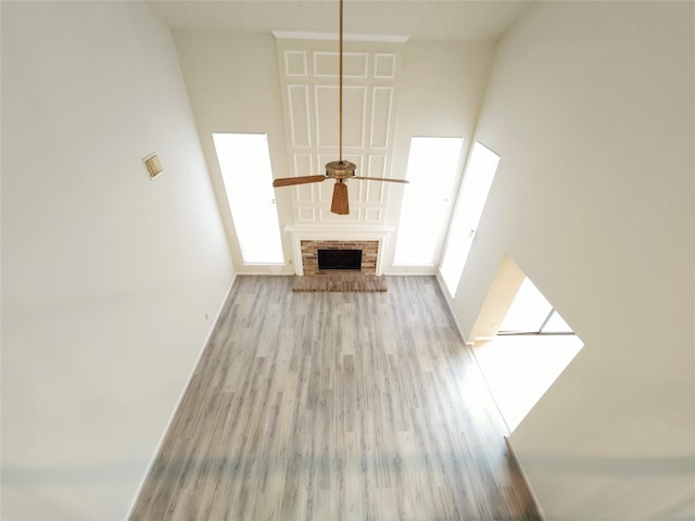 3226 Country Club Blvd, Stafford, TX 77477 - unfurnished living room with a ceiling fan, wood finished floors, a brick fireplace, and a high ceiling