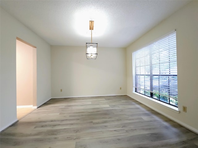 3226 Country Club Blvd, Stafford, TX 77477 - spare room with light wood-style flooring, baseboards, and a textured ceiling