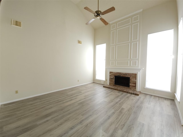 3226 Country Club Blvd, Stafford, TX 77477 - unfurnished living room with high vaulted ceiling, a ceiling fan, light wood-style flooring, baseboards, and a brick fireplace