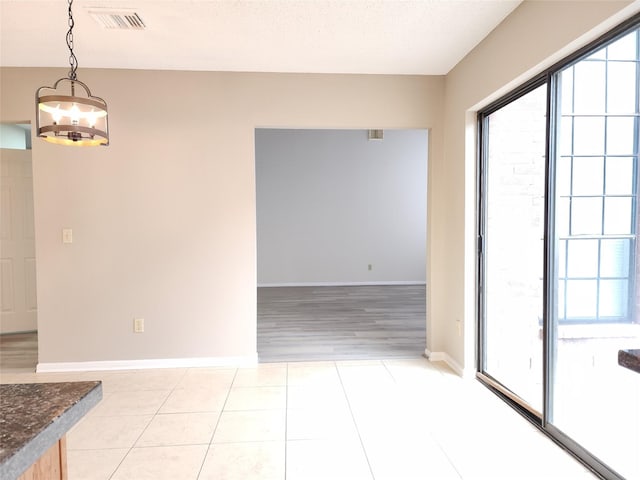 3226 Country Club Blvd, Stafford, TX 77477 - unfurnished dining area featuring a chandelier, light tile patterned flooring, and baseboards