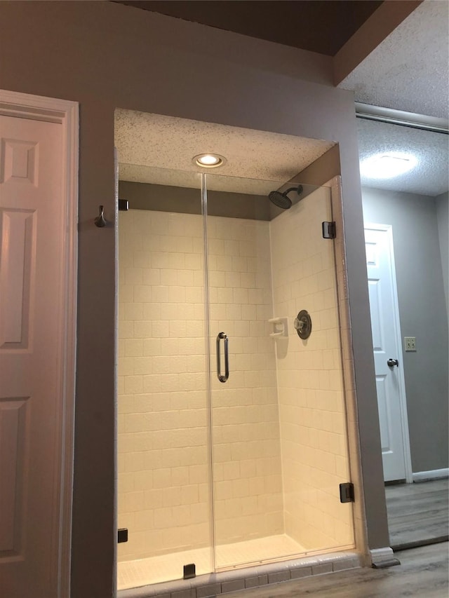 3226 Country Club Blvd, Stafford, TX 77477 - bathroom featuring a stall shower, a textured ceiling, wood finished floors, and baseboards
