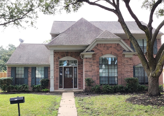 3226 Country Club Blvd, Stafford, TX 77477 - french provincial home with brick siding, roof with shingles, and a front lawn