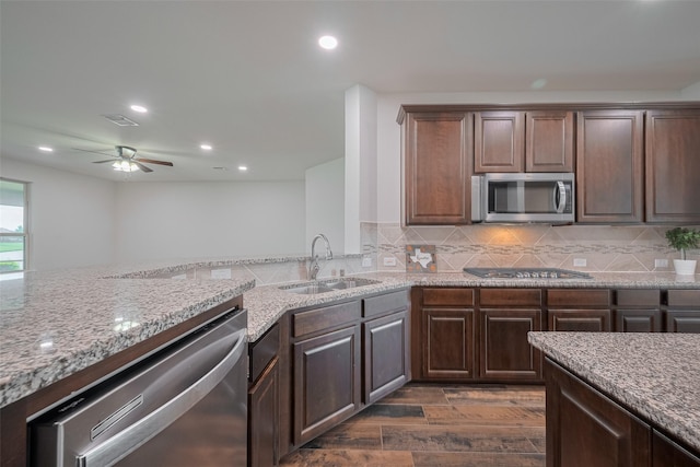 430 Seaside Sparrow Way, Richmond, TX 77469 - kitchen featuring appliances with stainless steel finishes, a sink, light stone countertops, a ceiling fan, and dark wood-type flooring
