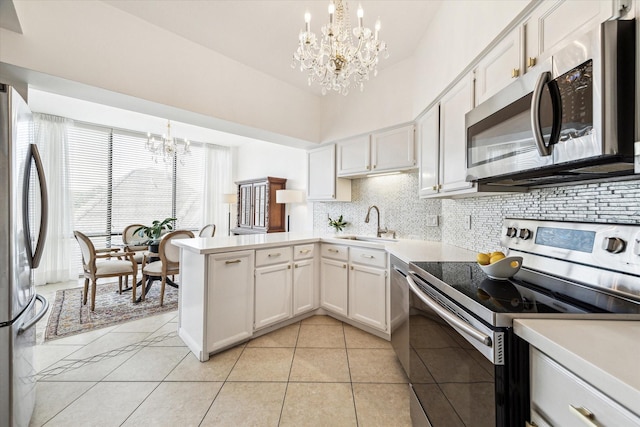 1111 Bering Dr Unit 301, Houston, TX 77057 - kitchen featuring appliances with stainless steel finishes, a chandelier, backsplash, a peninsula, and a sink