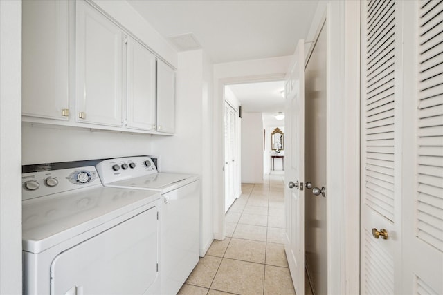 1111 Bering Dr Unit 301, Houston, TX 77057 - laundry area featuring cabinet space, light tile patterned floors, and washing machine and dryer