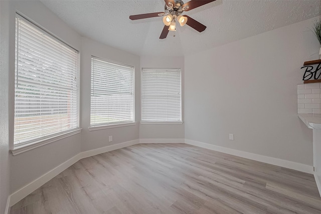 22010 Rivermead Dr, Katy, TX 77449 - spare room with light wood-style flooring, a textured ceiling, a ceiling fan, and baseboards