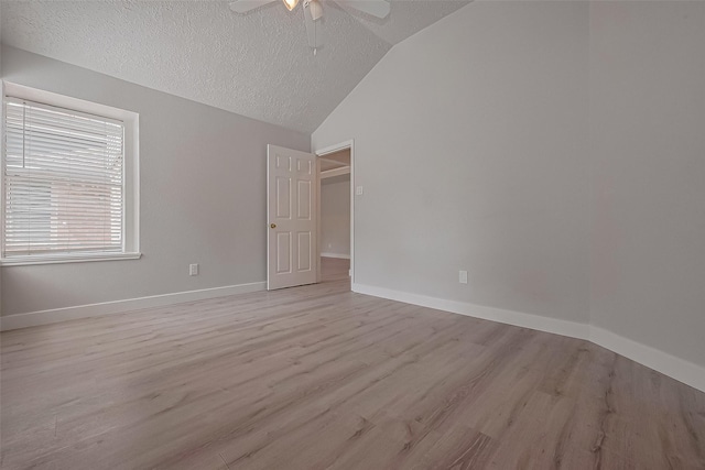 22010 Rivermead Dr, Katy, TX 77449 - spare room featuring vaulted ceiling, a textured ceiling, a ceiling fan, light wood-style flooring, and baseboards