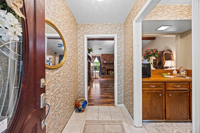 11855 23rd St, Santa Fe, TX 77510 - foyer entrance featuring wallpapered walls, light tile patterned floors, and baseboards