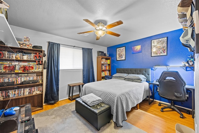 11855 23rd St, Santa Fe, TX 77510 - bedroom with wood finished floors, ceiling fan, and a textured ceiling